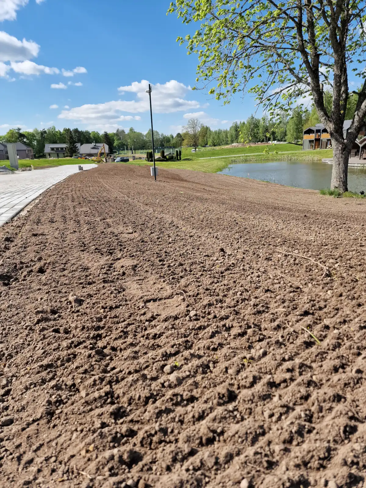 Greeneris darbuotojų supurenta augavietė vejos įrengimui ant šlaito.
