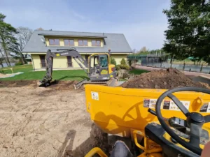 Greeneris darbuotojai sunkiasvore technika nukasa armenį - derlingą dirvos sluoksnį prieš įrengiant takelį.